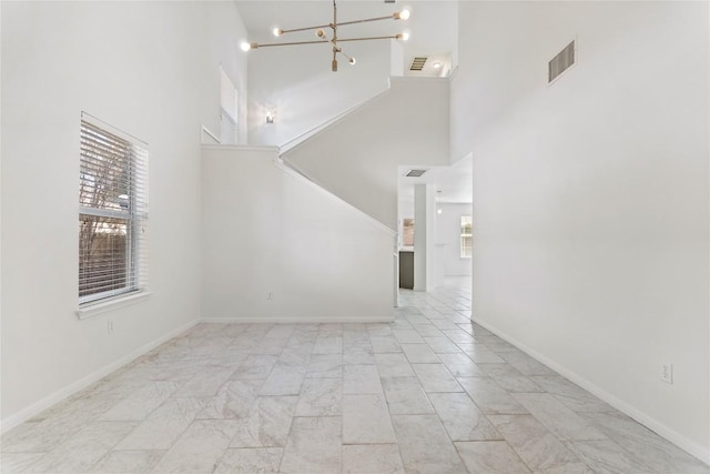 interior space with an inviting chandelier, plenty of natural light, and a high ceiling