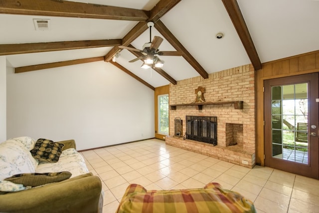 living room with ceiling fan, vaulted ceiling with beams, light tile patterned floors, and a fireplace