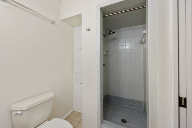 bathroom with tiled shower, tile patterned floors, and toilet