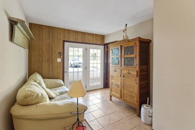 sitting room featuring light tile patterned flooring and wood walls