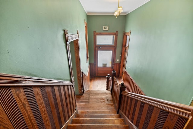 staircase featuring crown molding and wood-type flooring