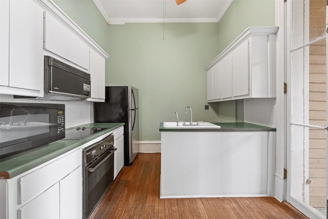 kitchen featuring white cabinetry, crown molding, dark hardwood / wood-style flooring, and black appliances