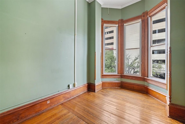 empty room featuring light hardwood / wood-style flooring and ornamental molding