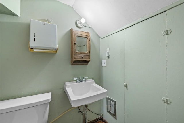 bathroom featuring vaulted ceiling, sink, and toilet