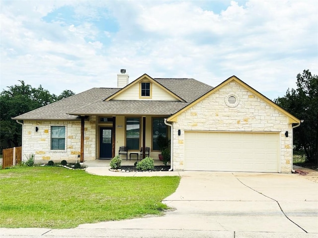 view of front of house with covered porch, a garage, and a front yard