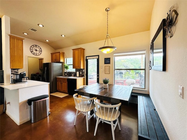 kitchen with plenty of natural light, pendant lighting, black appliances, and vaulted ceiling