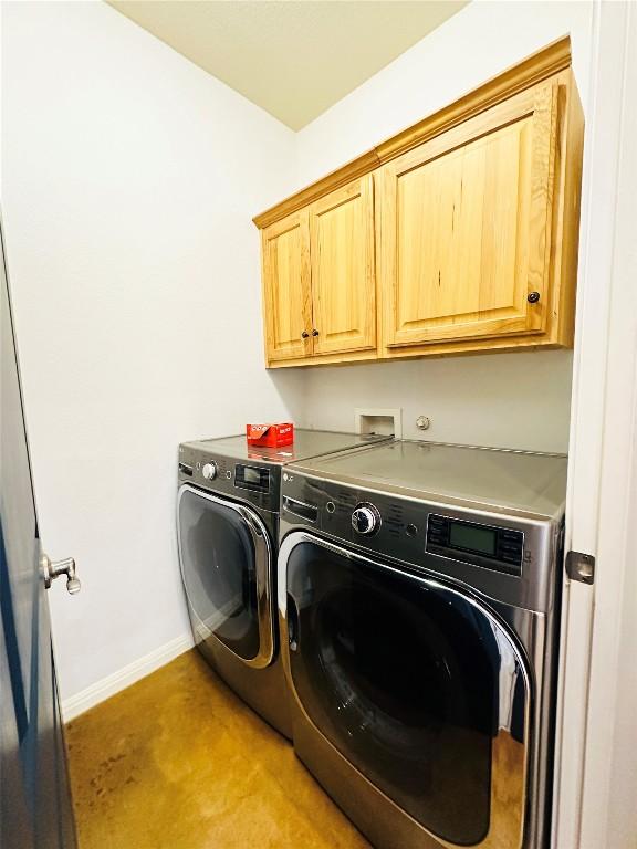 laundry room with separate washer and dryer and cabinets