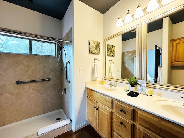 bathroom featuring tiled shower and vanity