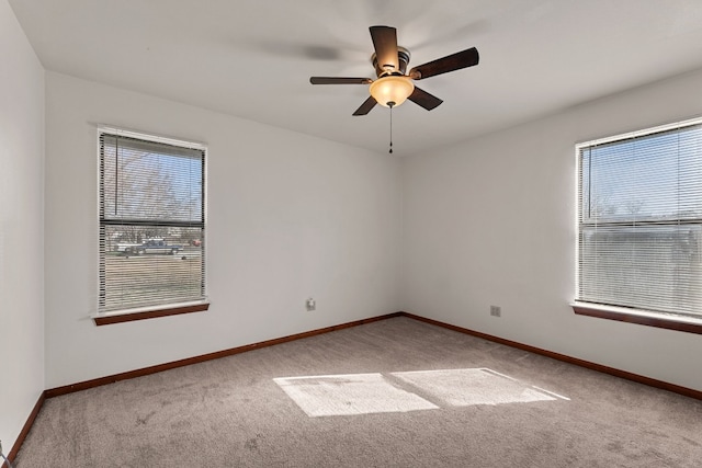 carpeted empty room with ceiling fan and a healthy amount of sunlight