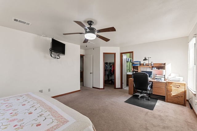 carpeted bedroom featuring a walk in closet, ceiling fan, and a closet