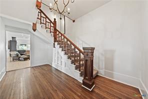 stairs with hardwood / wood-style flooring and a chandelier