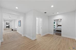 corridor with light hardwood / wood-style floors