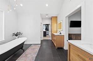 bathroom with tile patterned floors, vanity, and a bathing tub