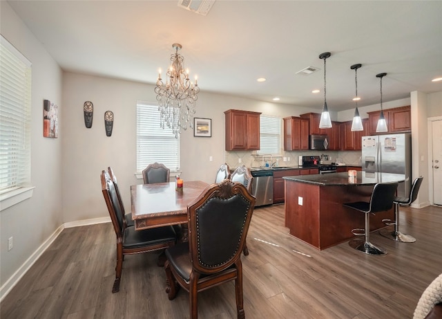 dining room with dark hardwood / wood-style floors, sink, and a notable chandelier