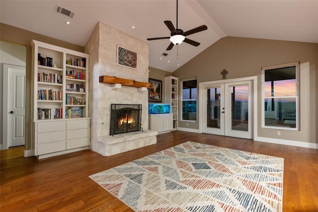 living room featuring french doors, lofted ceiling, wood-type flooring, ceiling fan, and a fireplace