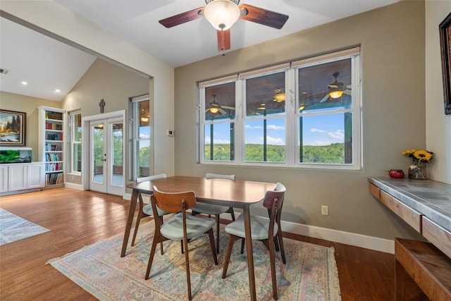 dining room with hardwood / wood-style flooring, vaulted ceiling, and french doors