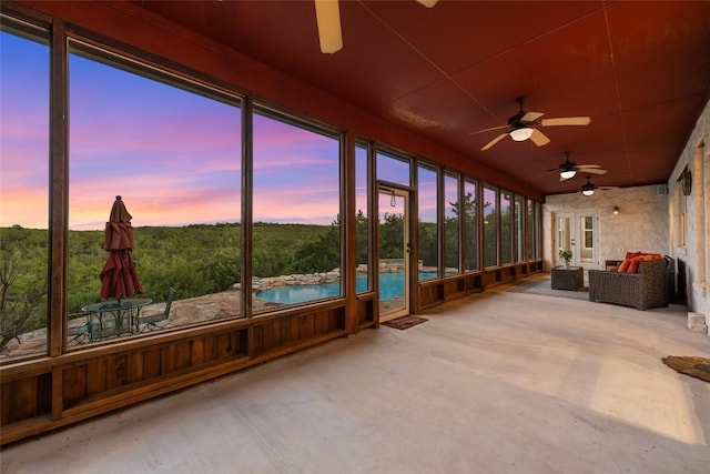 unfurnished sunroom featuring ceiling fan