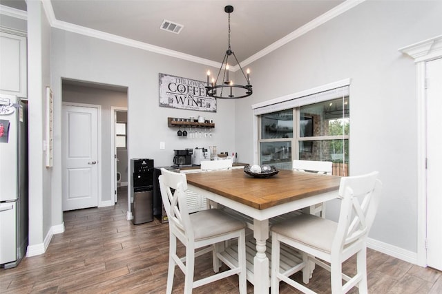 dining area featuring an inviting chandelier, crown molding, and dark wood-type flooring