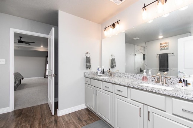 bathroom with vanity, hardwood / wood-style floors, an enclosed shower, and ceiling fan