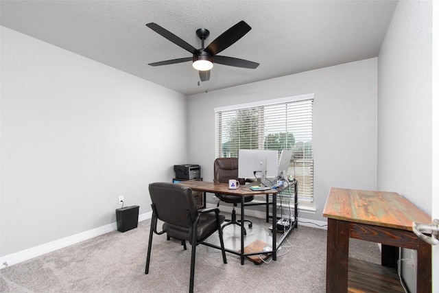 office space featuring light colored carpet, a textured ceiling, and ceiling fan