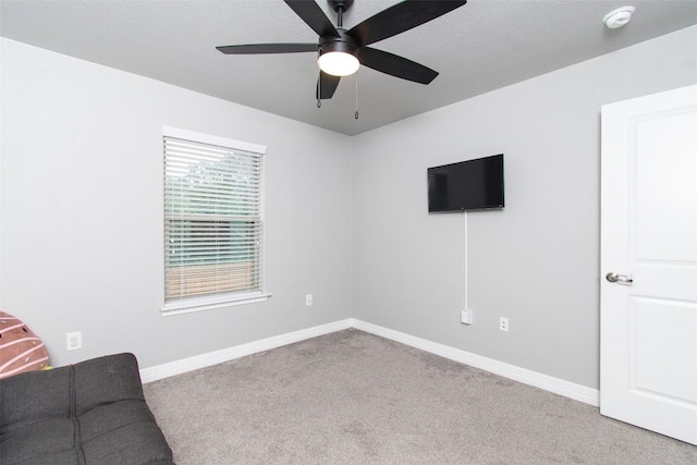 unfurnished room featuring light colored carpet, a textured ceiling, and ceiling fan