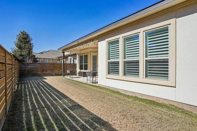 view of side of home featuring a yard and a patio area