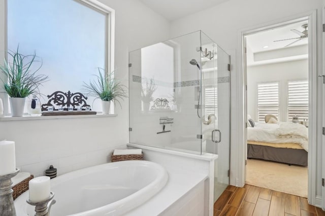 bathroom with independent shower and bath and hardwood / wood-style floors