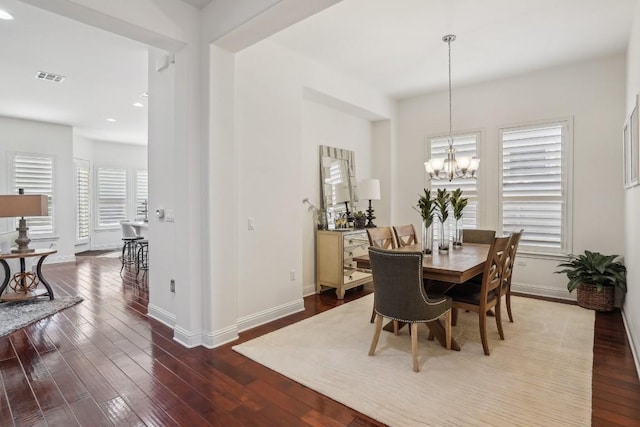 dining area featuring hardwood / wood-style flooring and a notable chandelier