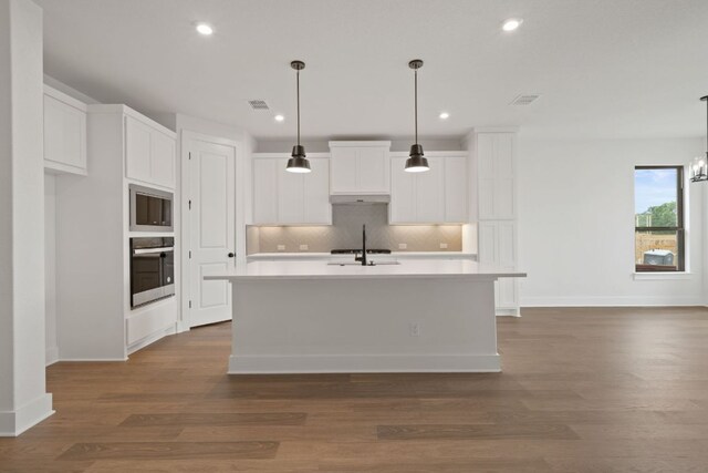 1243 Robin Trl, Round Rock, TX 78681 - kitchen featuring stainless steel oven, built in microwave, backsplash, white cabinets, and recessed lighting