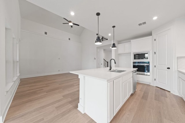 1243 Robin Trl, Round Rock, TX 78681 - kitchen featuring appliances with stainless steel finishes, a sink, white cabinets, light wood-type flooring, and recessed lighting