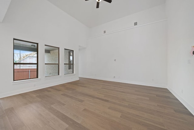 1243 Robin Trl, Round Rock, TX 78681 - empty room featuring ceiling fan, wood finished floors, baseboards, and a towering ceiling