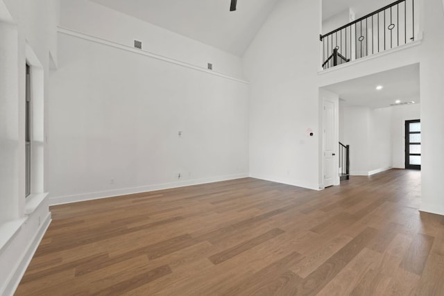 1243 Robin Trl, Round Rock, TX 78681 - unfurnished room with stairs, high vaulted ceiling, wood finished floors, and baseboards