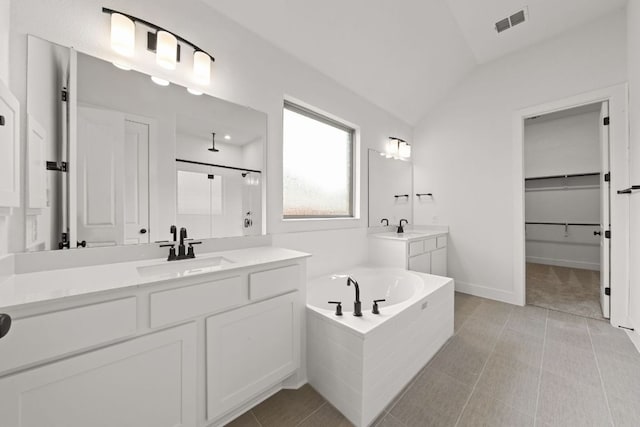 1243 Robin Trl, Round Rock, TX 78681 - full bathroom featuring a shower stall, a garden tub, two vanities, vaulted ceiling, and a walk in closet