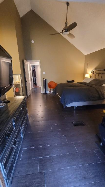 bedroom featuring high vaulted ceiling, dark wood-type flooring, and ceiling fan