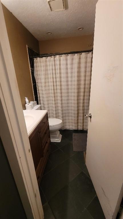 12410 Twin Creek Rd, Manchaca, TX 78652 - bathroom with a textured ceiling, visible vents, toilet, vanity, and tile patterned flooring