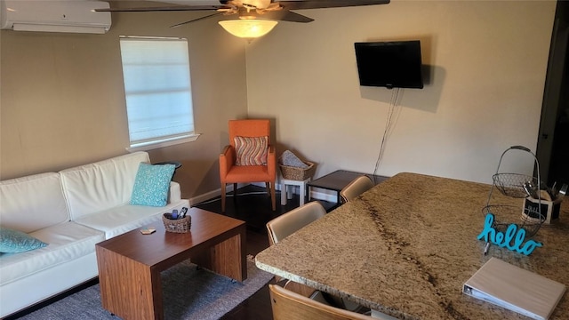 living room featuring ceiling fan and an AC wall unit