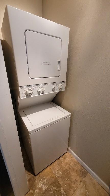 12410 Twin Creek Rd, Manchaca, TX 78652 - laundry room with stacked washer / dryer, a textured wall, baseboards, and laundry area