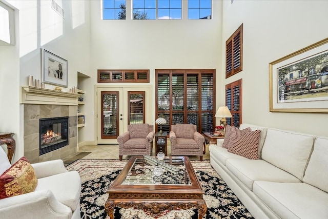 tiled living room with french doors, a fireplace, and a high ceiling