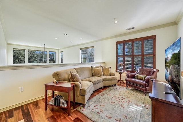 living room featuring a healthy amount of sunlight, ornamental molding, and hardwood / wood-style floors