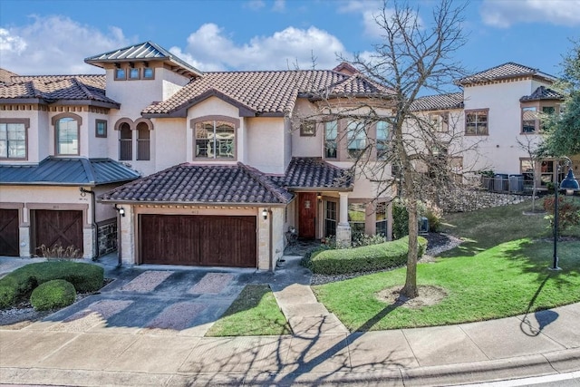 mediterranean / spanish-style home with a garage and a front lawn