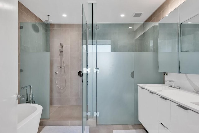 bathroom featuring vanity, independent shower and bath, and tile patterned flooring