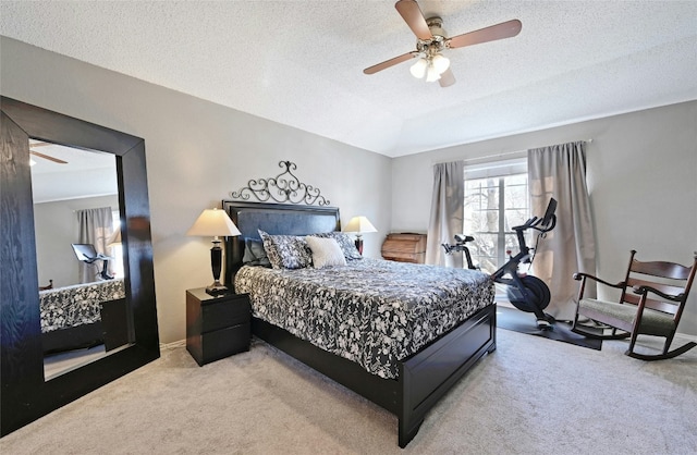 carpeted bedroom with ceiling fan and a textured ceiling