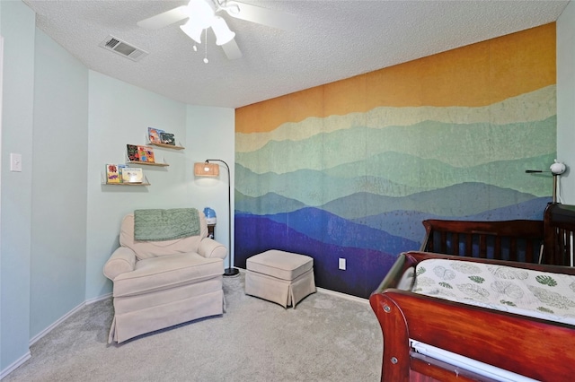 carpeted bedroom featuring ceiling fan and a textured ceiling