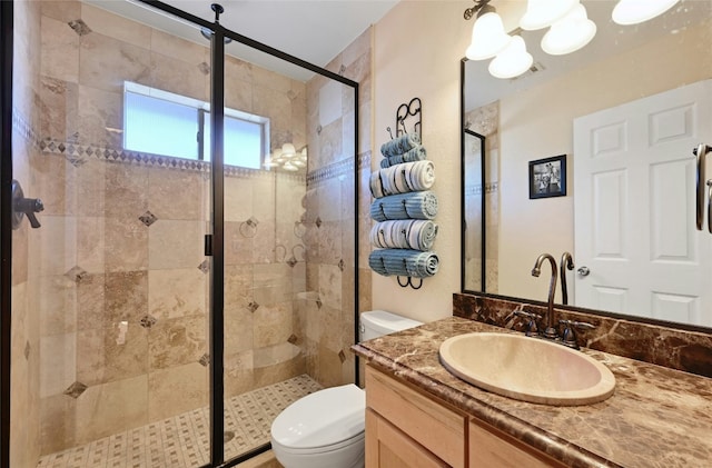 bathroom with vanity, a shower with shower door, and toilet