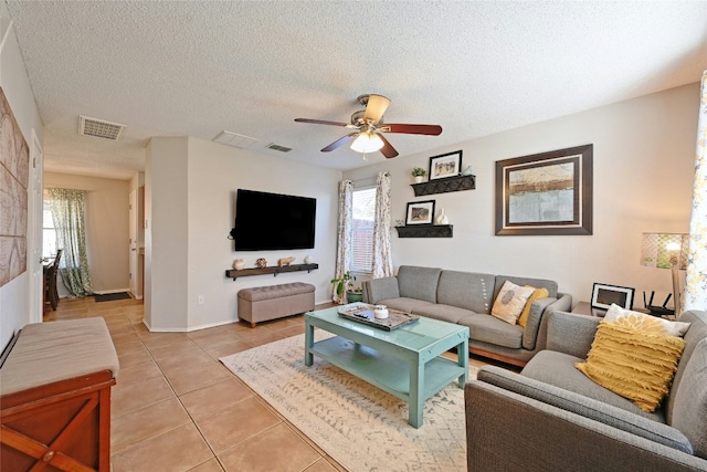 living room featuring light tile patterned floors, a textured ceiling, and ceiling fan