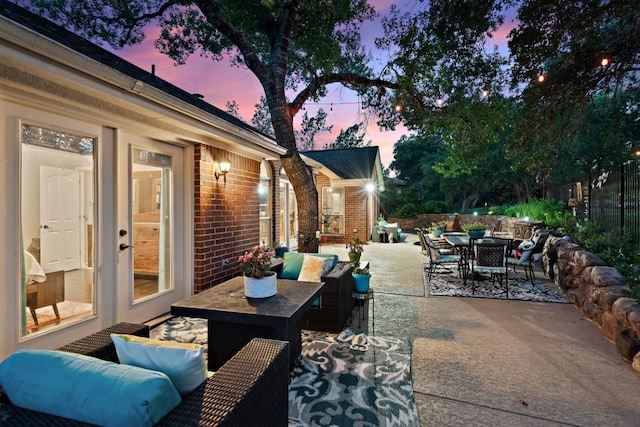 patio terrace at dusk featuring an outdoor living space