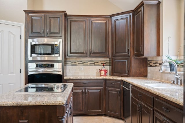 kitchen with sink, backsplash, light tile patterned floors, dark brown cabinetry, and stainless steel appliances