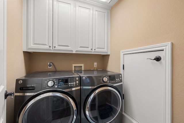 laundry area featuring separate washer and dryer and cabinets