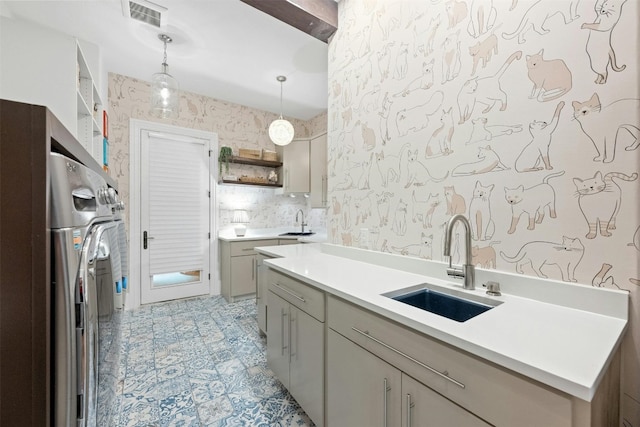 kitchen featuring washer / clothes dryer, sink, and decorative light fixtures