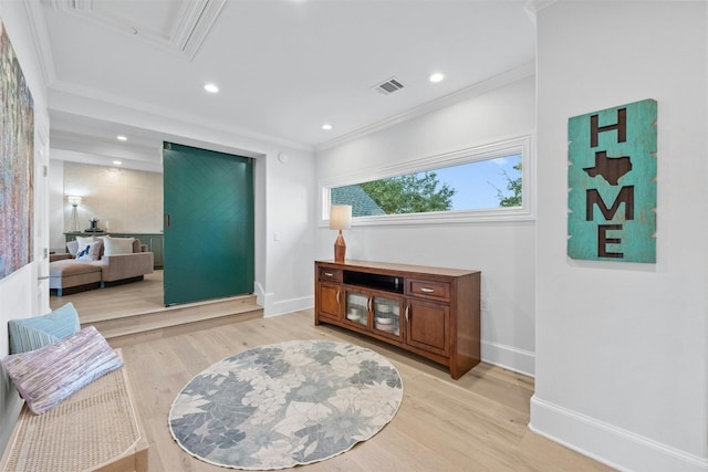 sitting room featuring ornamental molding and light wood-type flooring